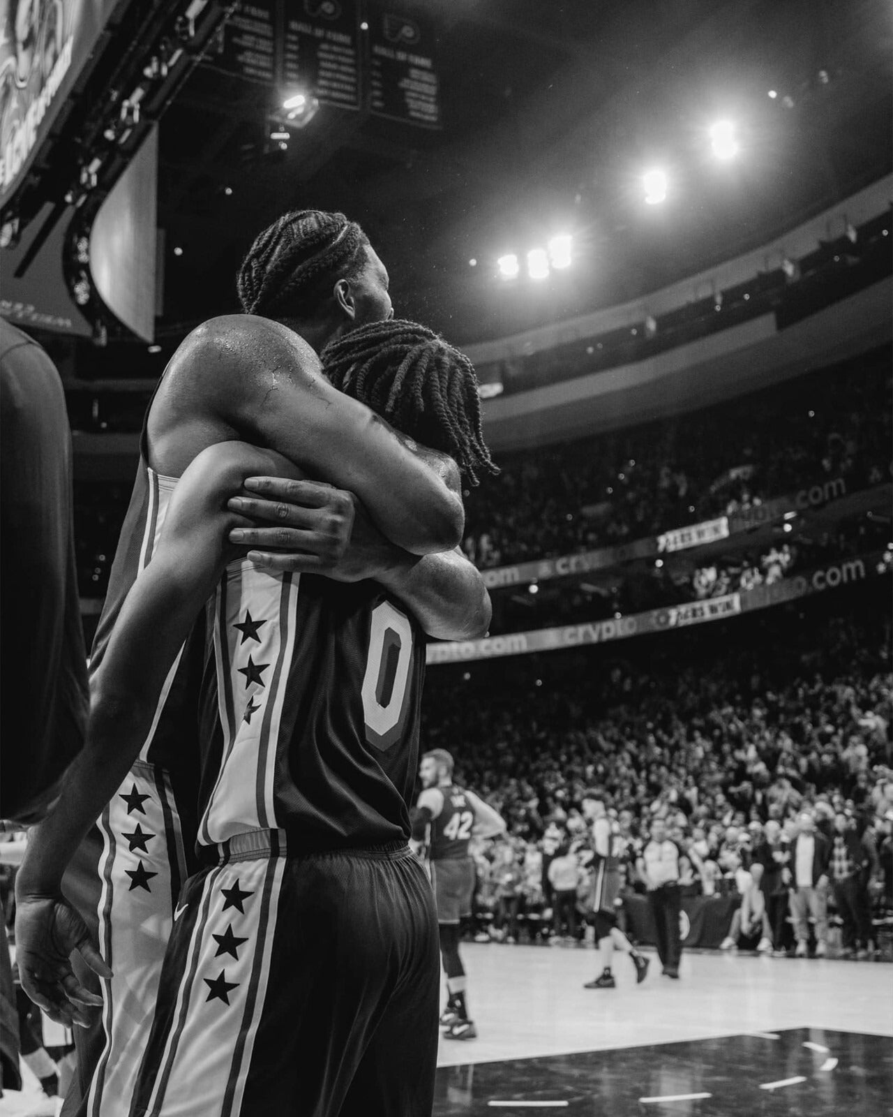 Joel Embiid and Tyrese Maxey hugging black and white canvas wall art