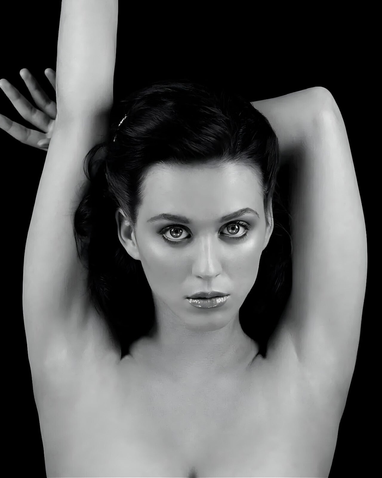 Katy Perry Black and white portrait of a woman with her arms raised against a black background