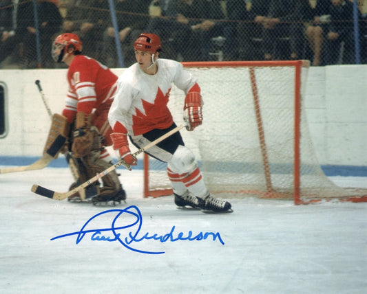 An autographed sports photo of hockey player Paul Anderson in a white and red Canada jersey on the ice, with a blue signature across the bottom.